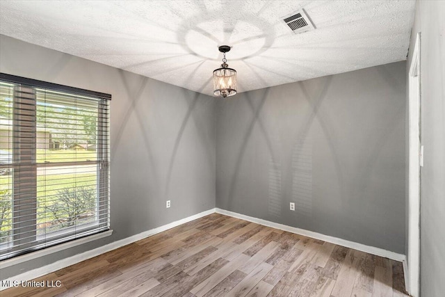 unfurnished room featuring a textured ceiling and hardwood / wood-style flooring