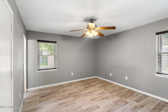 empty room featuring a textured ceiling, light hardwood / wood-style floors, and ceiling fan