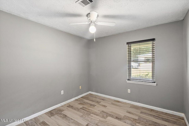 unfurnished room with a textured ceiling, light wood-type flooring, and ceiling fan