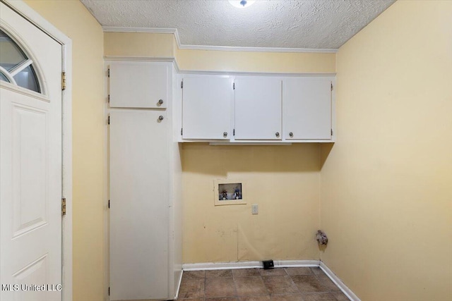 washroom with dark tile patterned floors, washer hookup, crown molding, cabinets, and a textured ceiling