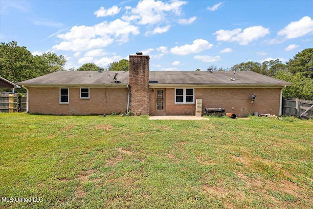 back of house with a patio and a lawn