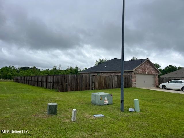 view of yard featuring an attached garage and driveway