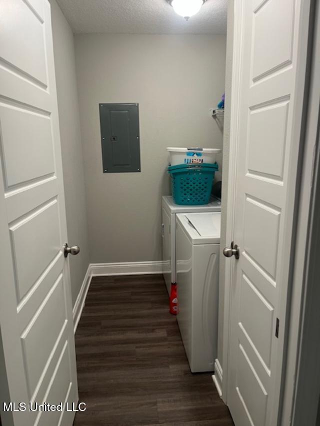 laundry room featuring electric panel, washing machine and dryer, dark wood-style floors, baseboards, and a textured ceiling
