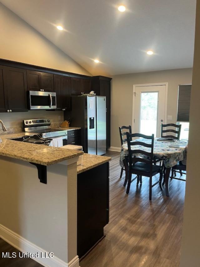 kitchen with stainless steel appliances, light stone countertops, dark wood-style floors, baseboards, and recessed lighting