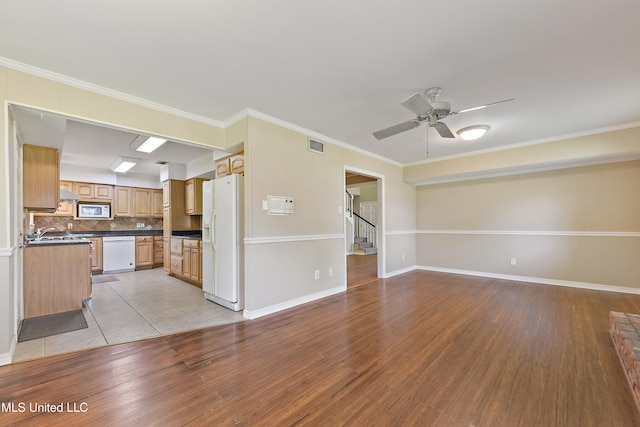 interior space featuring ornamental molding, light hardwood / wood-style floors, white appliances, and tasteful backsplash