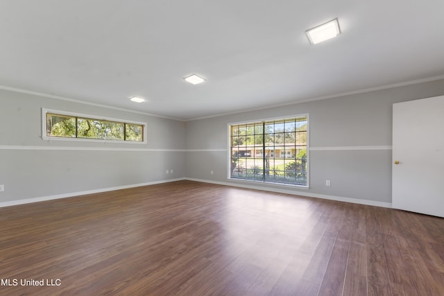 spare room featuring crown molding and dark hardwood / wood-style flooring