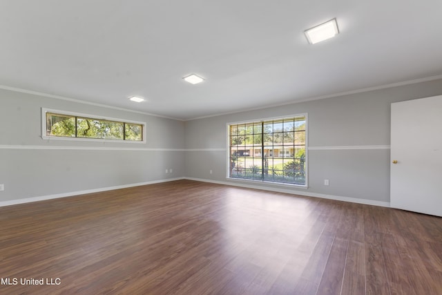 unfurnished room featuring crown molding, dark wood-style floors, and baseboards