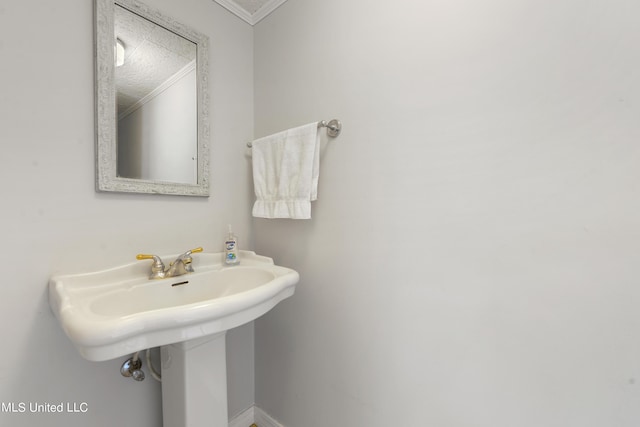bathroom with ornamental molding and baseboards