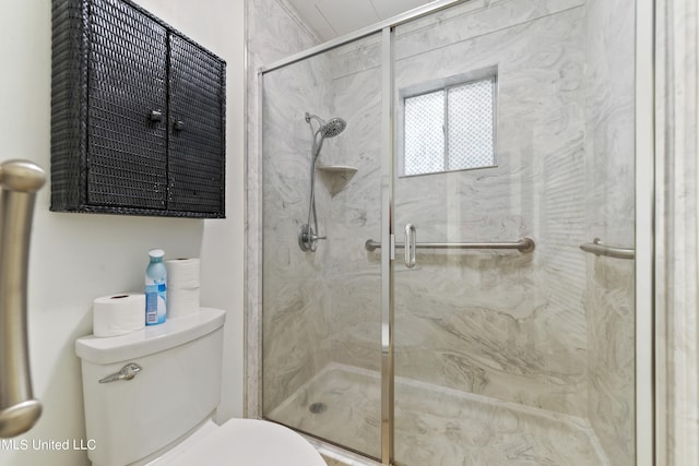 bathroom with a shower with door and toilet