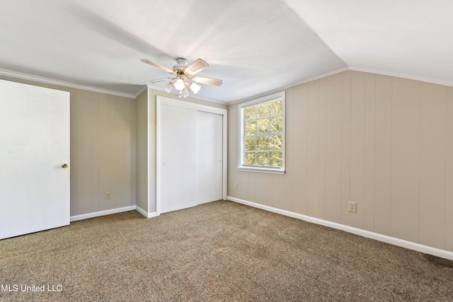 unfurnished bedroom with lofted ceiling, crown molding, carpet floors, and ceiling fan