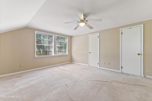 interior space with vaulted ceiling, light carpet, and ceiling fan