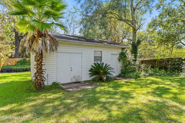 view of outbuilding featuring an outdoor structure and fence