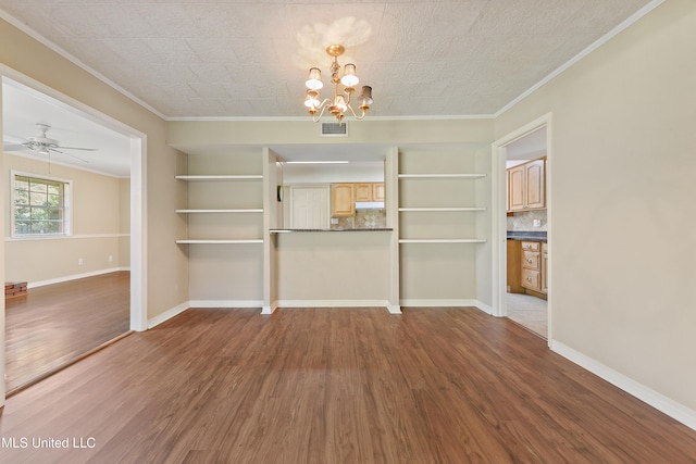 unfurnished dining area featuring crown molding, wood-type flooring, ceiling fan with notable chandelier, and built in shelves