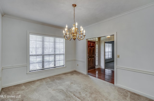 carpeted empty room with baseboards, an inviting chandelier, and crown molding