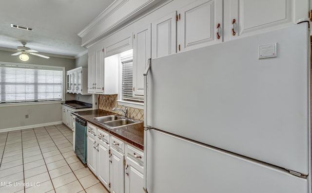 kitchen featuring a sink, visible vents, black dishwasher, freestanding refrigerator, and crown molding