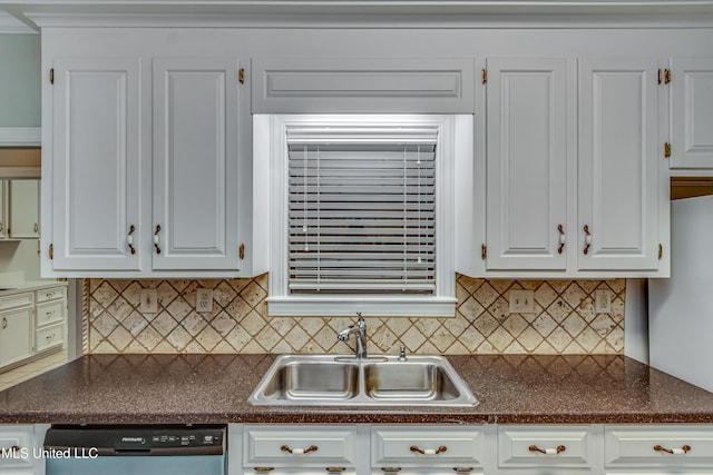 kitchen featuring dark countertops, dishwasher, white cabinetry, and a sink