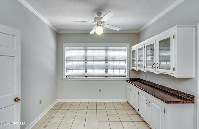 interior space with light tile patterned floors, crown molding, baseboards, and ceiling fan