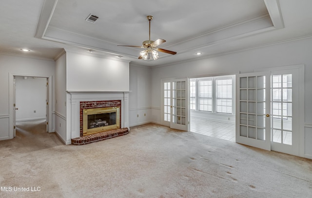 unfurnished living room featuring carpet floors, a fireplace, visible vents, french doors, and a tray ceiling