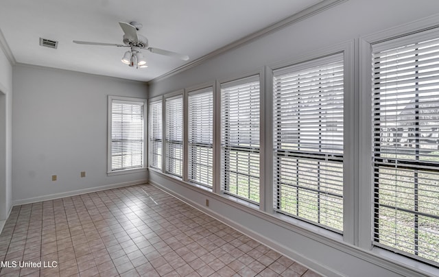 unfurnished room with a ceiling fan, visible vents, crown molding, and baseboards