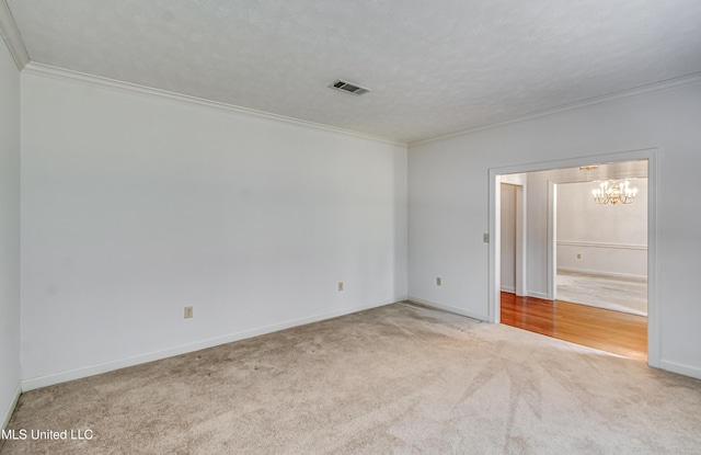 spare room featuring carpet floors, visible vents, and ornamental molding