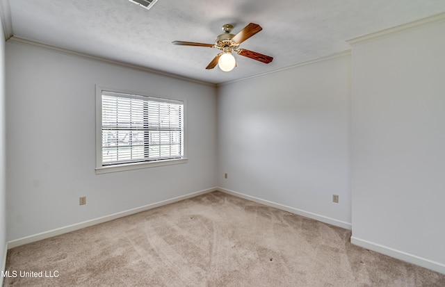 carpeted spare room featuring crown molding, visible vents, a ceiling fan, a textured ceiling, and baseboards