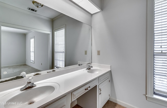 bathroom with double vanity, visible vents, a sink, and ornamental molding