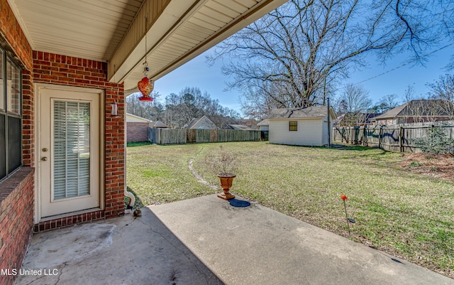 view of yard with an outbuilding, a patio, a storage unit, and a fenced backyard