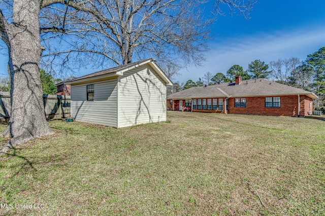 view of yard with an outdoor structure and fence