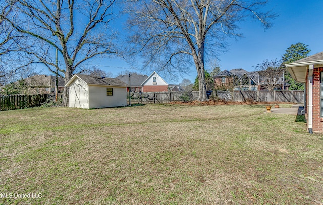 view of yard with a fenced backyard, an outdoor structure, and a storage unit