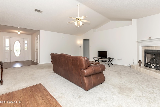 carpeted living room featuring ceiling fan, lofted ceiling, and a fireplace