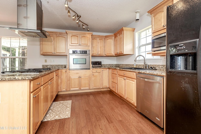 kitchen with light brown cabinets, light hardwood / wood-style flooring, a textured ceiling, island exhaust hood, and stainless steel appliances