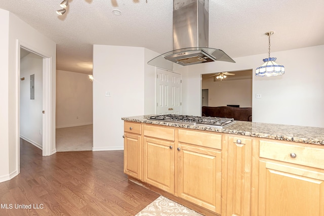 kitchen with pendant lighting, stainless steel gas stovetop, hardwood / wood-style flooring, light brown cabinetry, and island range hood