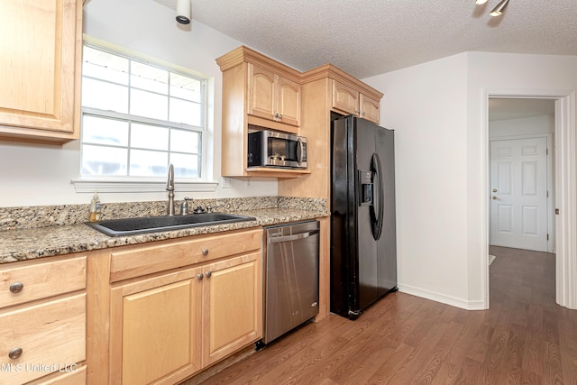 kitchen with light brown cabinets, sink, dark wood-type flooring, stainless steel appliances, and a textured ceiling