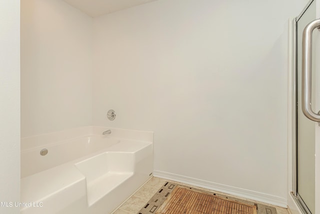 bathroom with tile patterned floors and a washtub