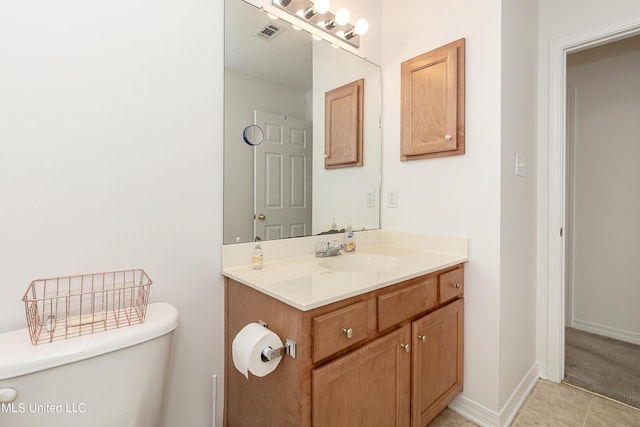 bathroom with tile patterned flooring, vanity, and toilet