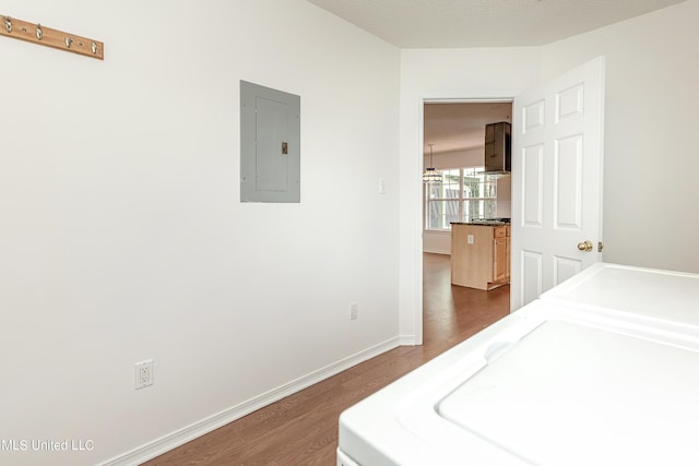 laundry area featuring a textured ceiling, electric panel, washer and dryer, and dark hardwood / wood-style floors