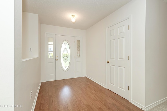 foyer entrance featuring light wood-type flooring and a textured ceiling