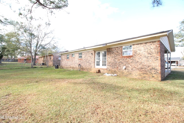 rear view of house featuring a yard and central AC unit