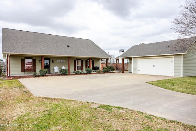 view of front facade with roof with shingles, driveway, a front yard, covered porch, and a garage