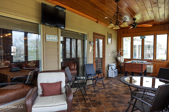 sunroom / solarium featuring wooden walls and wood ceiling