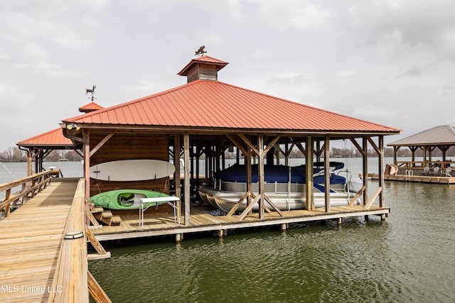 dock area with a water view, a gazebo, and boat lift