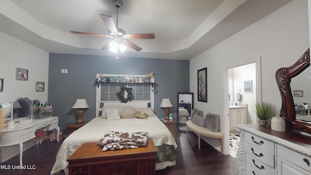 bedroom featuring ensuite bath, ceiling fan, dark hardwood / wood-style floors, and a raised ceiling