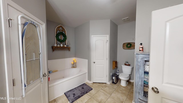 bathroom featuring toilet, tile patterned flooring, and a bathing tub