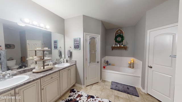 bathroom with toilet, a bathing tub, vanity, and tile patterned flooring