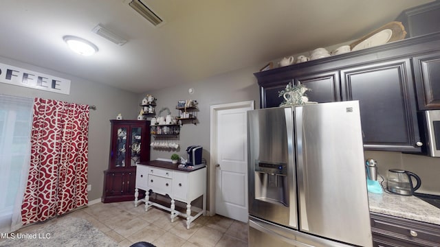 kitchen featuring stainless steel appliances, dark brown cabinets, and light tile patterned floors