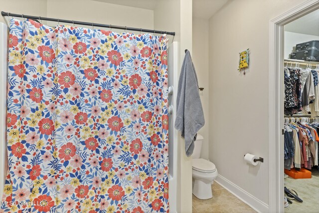 15035 Baylor Ave, Gulfport, MS 39503 - bathroom with toilet, a walk in closet, a shower with curtain, baseboards, and tile patterned flooring