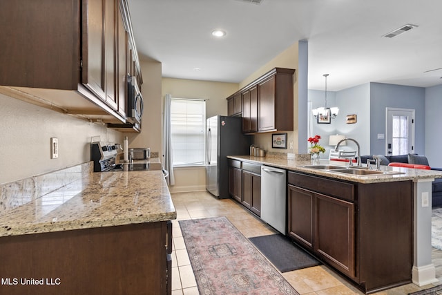 15035 Baylor Ave, Gulfport, MS 39503 - kitchen with stainless steel appliances, dark brown cabinets, a sink, a chandelier, and light tile patterned floors