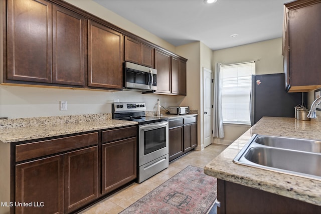 15035 Baylor Ave, Gulfport, MS 39503 - kitchen featuring stainless steel appliances, a sink, light tile patterned flooring, dark brown cabinetry, and recessed lighting