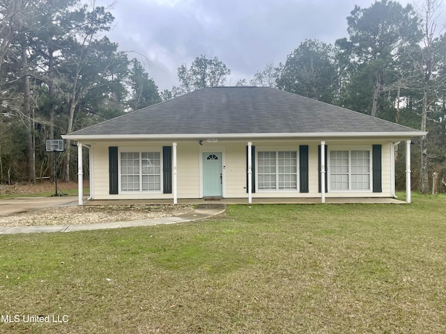 ranch-style house featuring a shingled roof, a front yard, covered porch, and a wall mounted AC