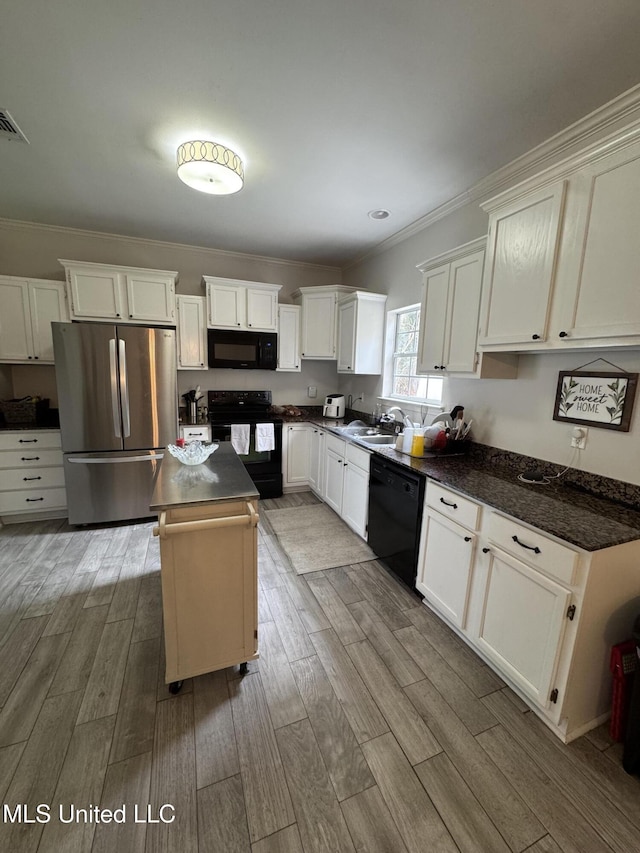 kitchen featuring black appliances, dark countertops, and wood finished floors